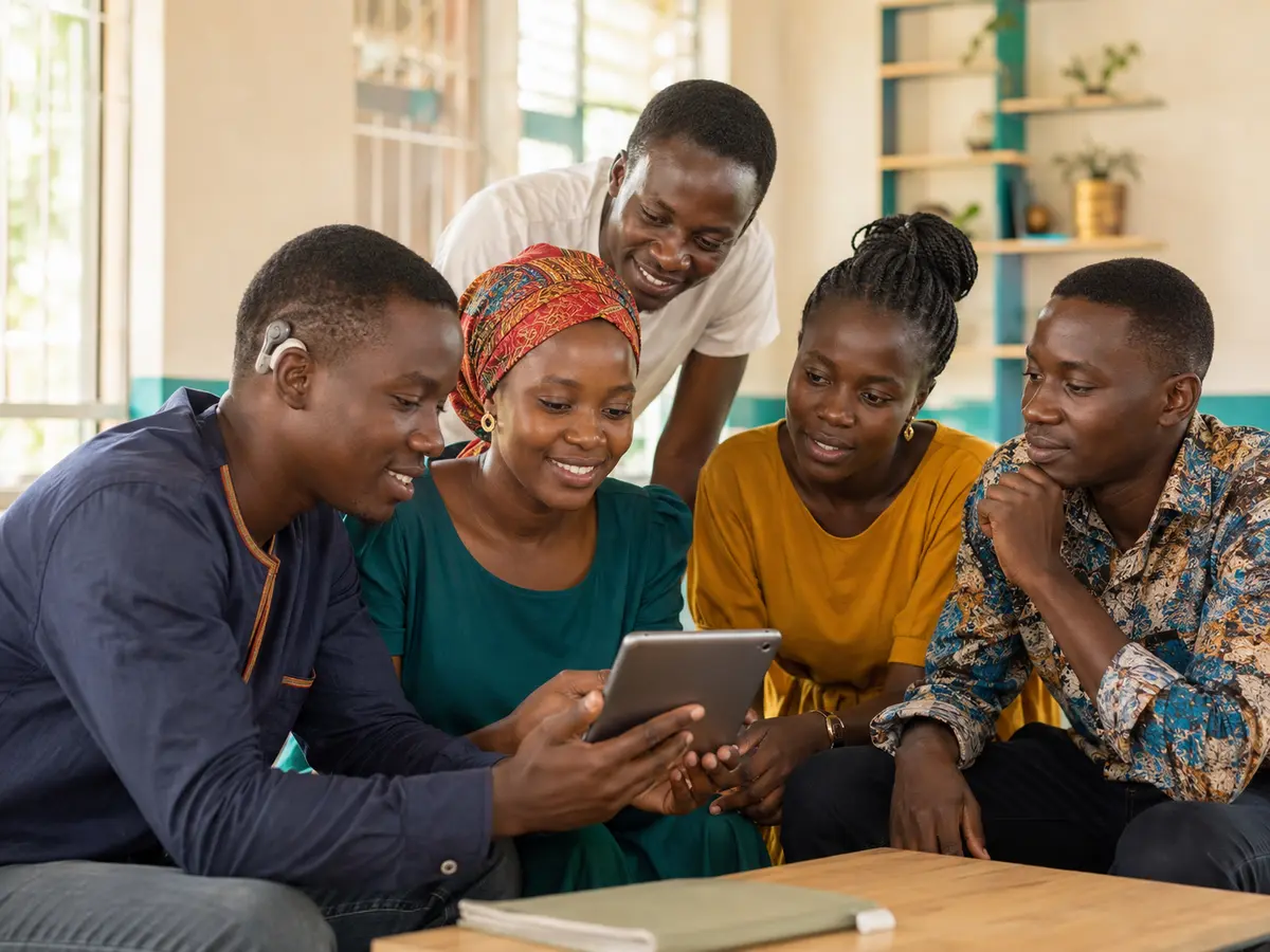 Young Black African refugees and host-community members reviewing practical information together